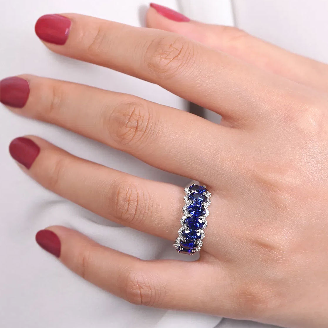 Hand wearing a sapphire and diamond ring